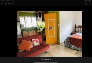 a living room with a red couch and a yellow door at Jimmyluh Self Catering in Durban