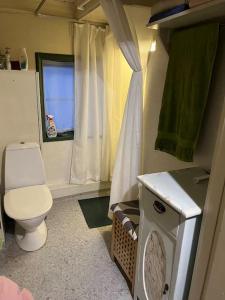 ein kleines Badezimmer mit Toilette und Fenster in der Unterkunft Det røde huset på Vågnes in Krokelvdalen