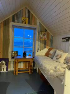 Habitación pequeña con cama y ventana en Det røde huset på Vågnes, en Krokelvdalen