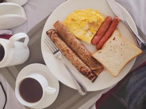 a plate of breakfast food with eggs sausage and toast at KILI CRANE LODGE ARUSHA in Arusha