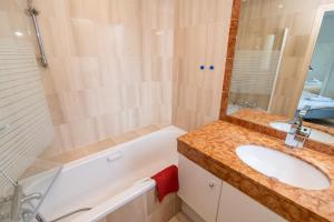 uma casa de banho com um lavatório e uma banheira em Bright and vast 1BR balcony parking heart of town 1 mn em Cannes