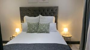 a bedroom with a large white bed with two lamps at Forest Hill in Pretoria
