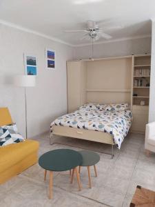 1 dormitorio con cama, mesa y sofá en Le Rove : la petite maison en Le Rove
