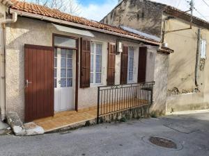 ein Haus mit einer Holztür und einer Veranda in der Unterkunft Le Rove : la petite maison in Le Rove