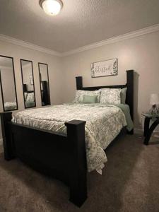a bedroom with a bed with a black frame at Cozy1King1Queen/1.5bth2min Frm UpTown in Lexington