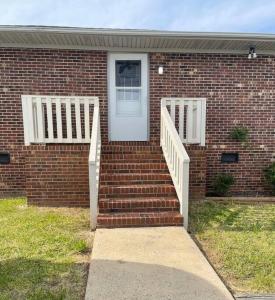 a brick house with a white door and stairs at Cozy1King1Queen/1.5bth2min Frm UpTown in Lexington