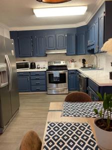 a kitchen with blue cabinets and a table with a table sidx sidx sidx at Cozy1King1Queen/1.5bth2min Frm UpTown in Lexington