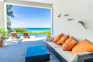 sala de estar con sofá y vistas al océano en 8卧沙滩别墅 3女佣 每日清洁 靠近机场 私人泳池 免费用车 健身房, en Phuket