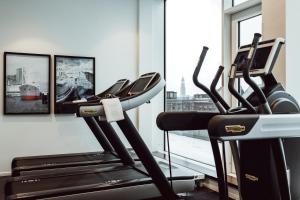 a gym with two treadmills in front of a window at AMERON Hamburg Hotel Speicherstadt in Hamburg