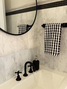 a bathroom sink with a faucet and a mirror at The Ranch - Coastal Farmhouse midway to Newcastle Airport and Beaches in Salt Ash