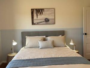 a bedroom with a large bed with two lamps at The Ranch - Coastal Farmhouse midway to Newcastle Airport and Beaches in Salt Ash