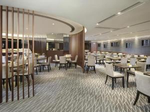 香港The Harbourview - Chinese YMCA of Hong Kong的配有桌椅和桌上电脑的用餐室