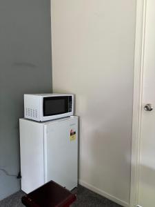 a microwave sitting on top of a refrigerator at Self checkin master room with private bathroom in Hamilton