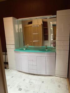 a bathroom with two sinks and a large mirror at Locations de la centrale de Belleville in Neuvy-sur-Loire