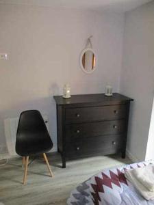 ein Schlafzimmer mit einer schwarzen Kommode und einem schwarzen Stuhl in der Unterkunft Casa Rural La Malena in Azuara