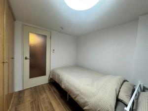 a small bedroom with a bed and a light at 【NEW OPEN】AMS Hiragishi 402 in Sapporo