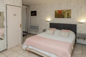 Chambres d'Ault في أولت: غرفة نوم مع سرير كبير مع وسائد وردية