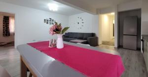 Fortuna Park Apartman في سفنتو جيورجي: غرفة معيشة مع طاولة مع إناء من الزهور عليها