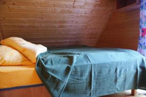 a bed in a room with a wooden wall at Two storey holiday houses for 4 people Jaros awiec in Jarosławiec