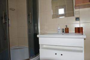 a bathroom with a sink and a shower and a mirror at Two storey holiday houses for 4 people Jaros awiec in Jarosławiec