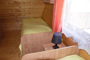 a small bed in a wooden room with a window at Two storey holiday houses for 4 people Jaros awiec in Jarosławiec
