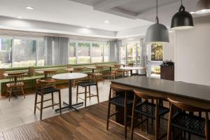 een restaurant met tafels, stoelen en ramen bij Fairfield Inn & Suites Portland West Beaverton in Beaverton