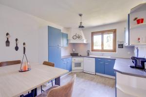 a kitchen with blue cabinets and a table with chairs at Authentic family home in Neuilly-sur-Marne in Neuilly-sur-Marne