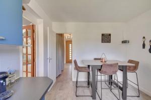 una cucina e una sala da pranzo con tavolo e sedie bianchi di Authentic family home in Neuilly-sur-Marne a Neuilly-sur-Marne