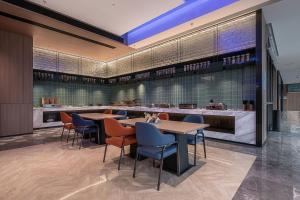 um restaurante com mesas e cadeiras e um bar em Holiday Inn Express Chongqing Nanbin Road, an IHG Hotel em Chongqing