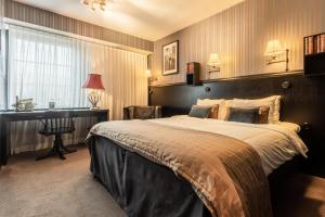 una camera d'albergo con un grande letto e una scrivania di Hotel & Ristorante Bellora a Göteborg