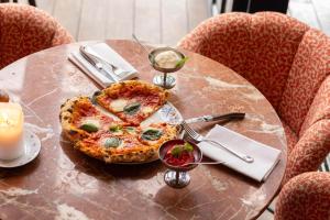 a pizza sitting on top of a table with a candle at Hotel & Ristorante Bellora in Gothenburg