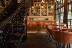 a bar with tables and chairs and a staircase at Hotel & Ristorante Bellora in Gothenburg