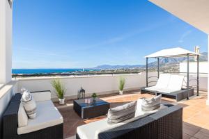 a patio with white furniture and a view of the ocean at Dúplex de Lujo Marbella Golf in Marbella