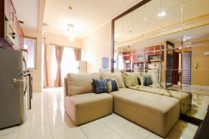 sala de estar con sofá y cocina en Sudirman Park Apartment, en Yakarta