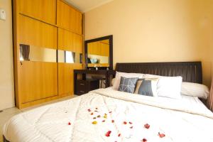 Un dormitorio con una cama grande con flores. en Sudirman Park Apartment, en Yakarta