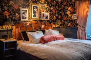 a bedroom with a bed with a red pillow on it at Hotel Pigalle in Gothenburg