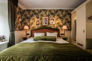 a bedroom with a large bed with a green blanket at Hotel Pigalle in Gothenburg