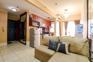 - un salon avec un canapé et un réfrigérateur dans l'établissement Sudirman Park Apartment, à Jakarta