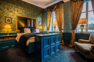 a bedroom with a bed and a couch and a window at Hotel Pigalle in Gothenburg