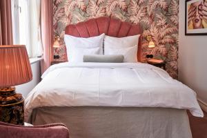 a bedroom with a large white bed with a red headboard at MJ's in Malmö