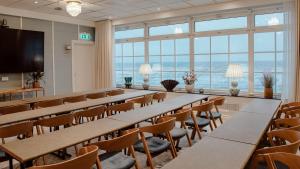 une salle de conférence avec des tables, des chaises et des fenêtres dans l'établissement Falkenberg Strandbad, à Falkenberg