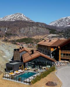 a resort with a swimming pool and mountains in the background at Fýri Resort in Hemsedal