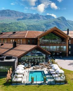a resort with a pool and chairs and a building at Fýri Resort in Hemsedal