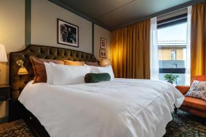 a bedroom with a large white bed and a window at Fýri Resort in Hemsedal