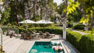 a swimming pool with chairs and a table and an umbrella at Villa Strandvägen in Ystad