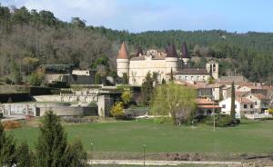 uma pequena cidade com um castelo numa colina em Les Sources Gite Cabernet em Chambonas