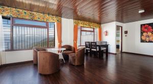 a living room with a table and chairs at Summit Sherpa Mountain Hotel & Spa in Kalimpong