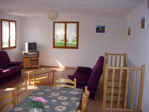 ein Wohnzimmer mit einem Sofa und einem Tisch in der Unterkunft Les Sources Gîte Sauvignon in Chambonas