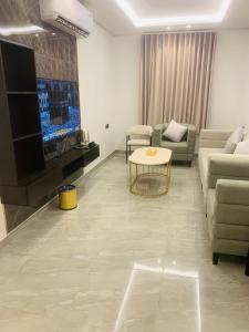 شقق كالم الفندقية في الرياض: غرفة معيشة مع أريكة وتلفزيون وطاولة