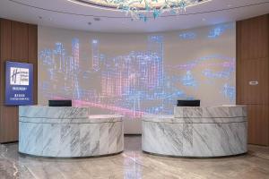 a lobby with two reception desks and a large screen at Holiday Inn Express Chongqing Nanbin Road, an IHG Hotel in Chongqing